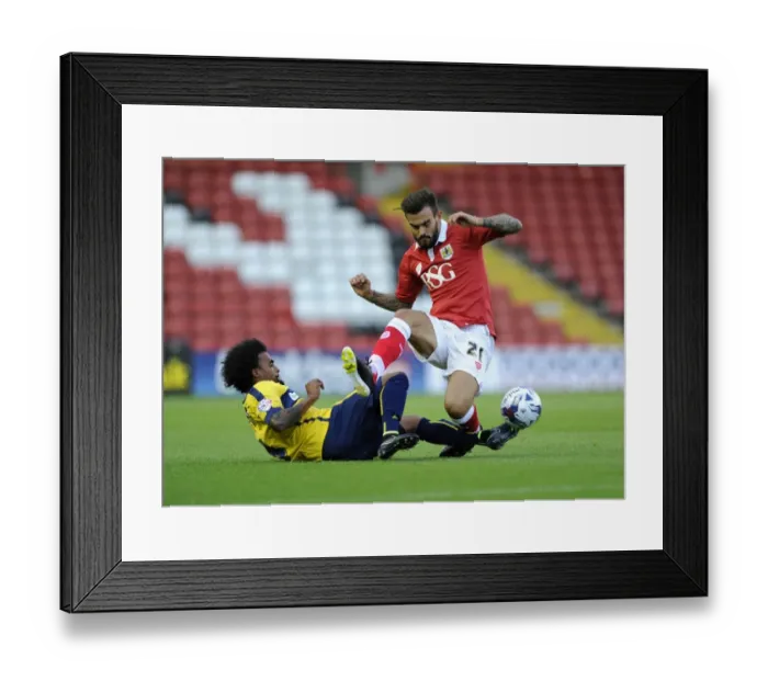 Framed Print : Marlon Pack vs. Junior Brown: Intense Battle for the Ball in Bristol City vs. Oxford United