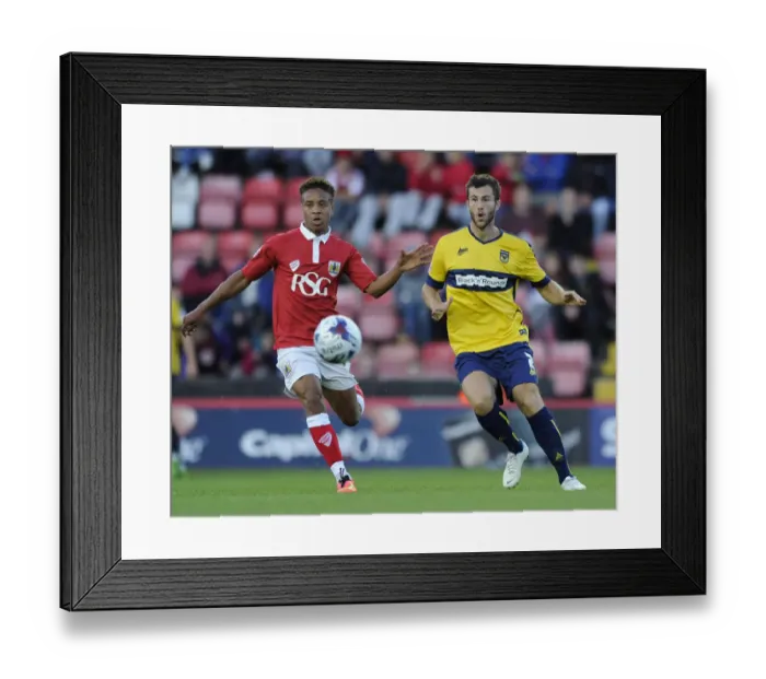 Framed Print : Bristol City vs Oxford United: Bobby Reid Pressures Jonathan Meades in First Round Capital One Cup Clash
