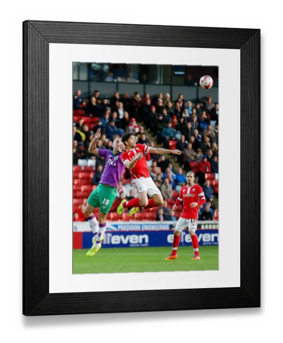 Framed Print : Bristol City's Wilbraham and Barnsley's Dudgeon Battle in the Air at Oakwell Stadium Framed Print : Bristol City's Wilbraham and Barnsley's Dudgeon Battle in the Air at Oakwell Stadium