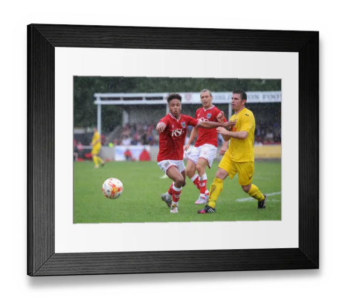 Framed Print : Bristol City's Bobby Reid Faces Off Against Brislington's James Peart in Pre-Season Clash Framed Print : Bristol City's Bobby Reid Faces Off Against Brislington's James Peart in Pre-Season Clash
