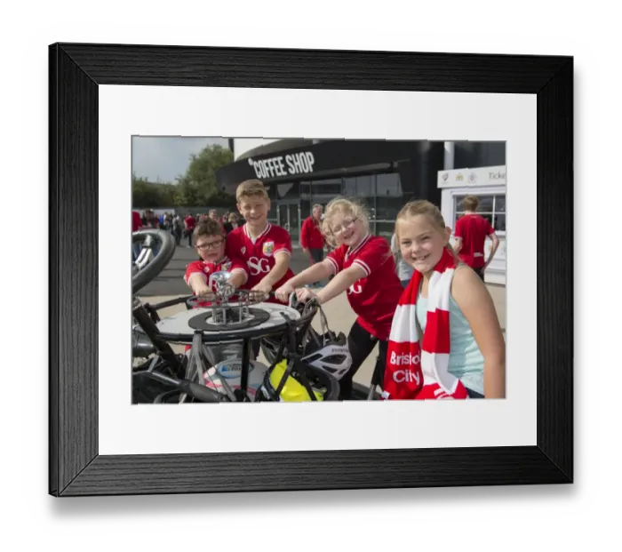 Framed Print : Bristol City Fans Gather Around Seven-Seater Bike for Children's Hospice South West Fundraiser at Ashton Gate Stadium Framed Print : Bristol City Fans Gather Around Seven-Seater Bike for Children's Hospice South West Fundraiser at Ashton Gate Stadium