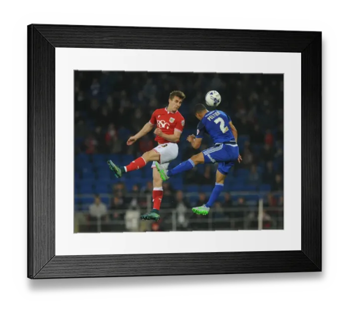 Framed Print : Bristol City's Joe Bryan Contests Header Against Cardiff City's Lee Peltier in Championship Clash