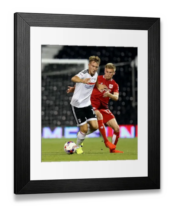 Framed Print : Cauley Woodrow vs Taylor Moore: A Battle at Craven Cottage - Fulham vs Bristol City EFL Cup Clash