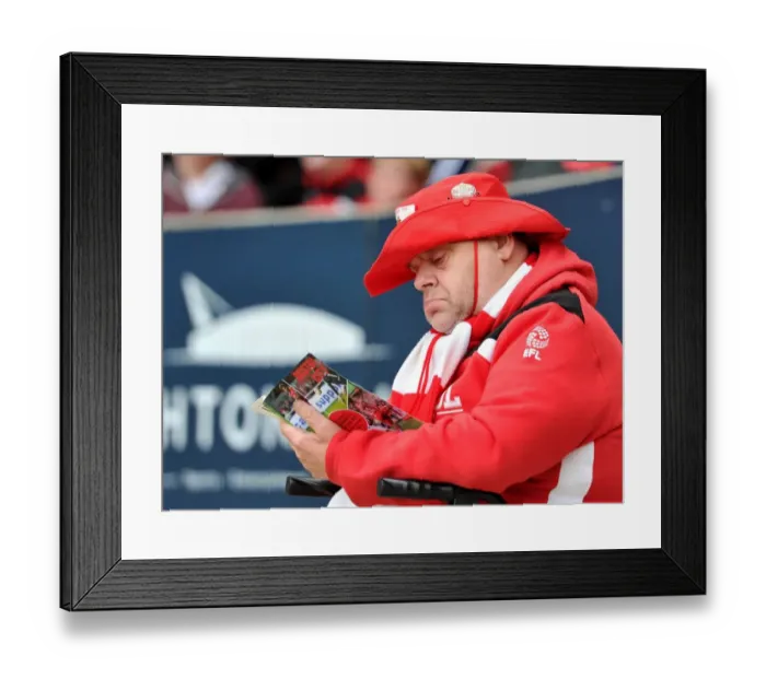 Framed Print : Bristol City Fan Delves into Match Program before Kick-off vs Blackburn Rovers, Sky Bet Championship, Ashton Gate Stadium