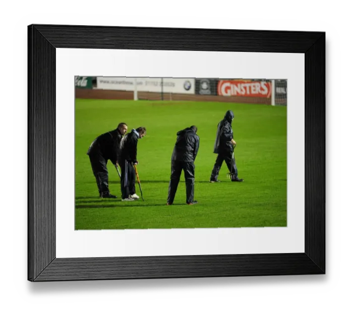 Framed Print : Groundsman work hard to make sure the pitch is playable