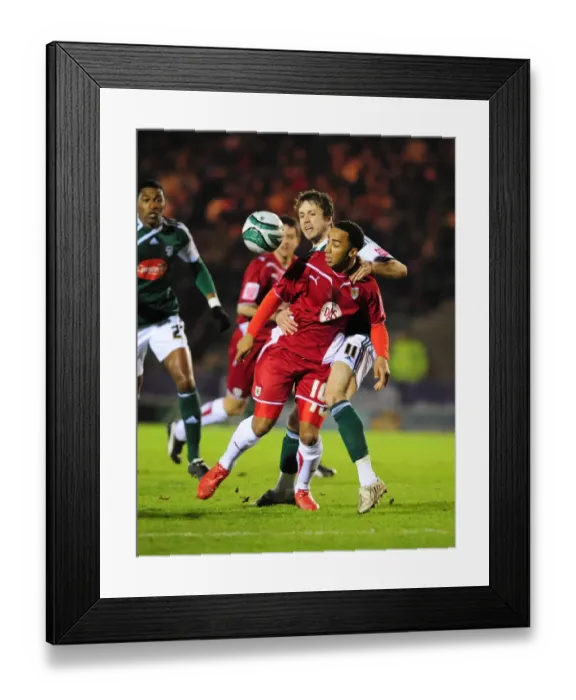 Framed Print : Bristol City's Nicky Maynard vs. Plymouth Argyle's Kari Arnason: Championship Clash at Home Park, 16th March 2010