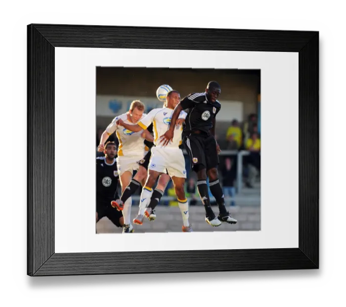 Framed Print : John Akinde Battles for Aerial Supremacy: Torquay vs. Bristol City