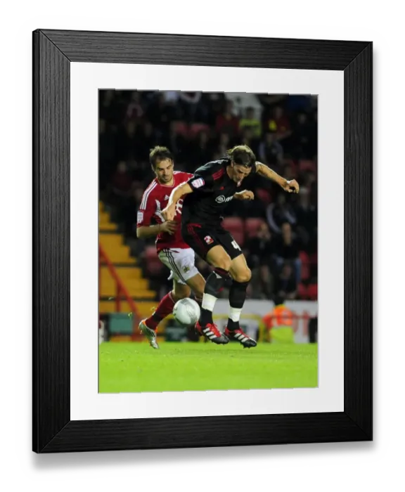 Framed Print : Battling for Supremacy: Brett Pitman vs. Aden Flint in the 2011 League Cup Clash between Bristol City and Swindon Town Framed Print : Battling for Supremacy: Brett Pitman vs. Aden Flint in the 2011 League Cup Clash between Bristol City and Swindon Town