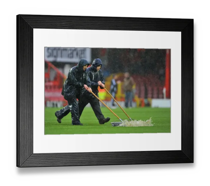 Framed Print : Winter's Battle: Referee Stops Bristol City vs. Watford Amidst Grounds Crew's Persistent Clearing Efforts