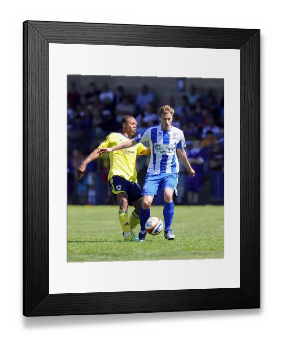 Framed Print : Bobby Reid vs Adi Adams: Intense Battle for the Ball in Clevedon Town vs Bristol City Pre-Season Clash Framed Print : Bobby Reid vs Adi Adams: Intense Battle for the Ball in Clevedon Town vs Bristol City Pre-Season Clash