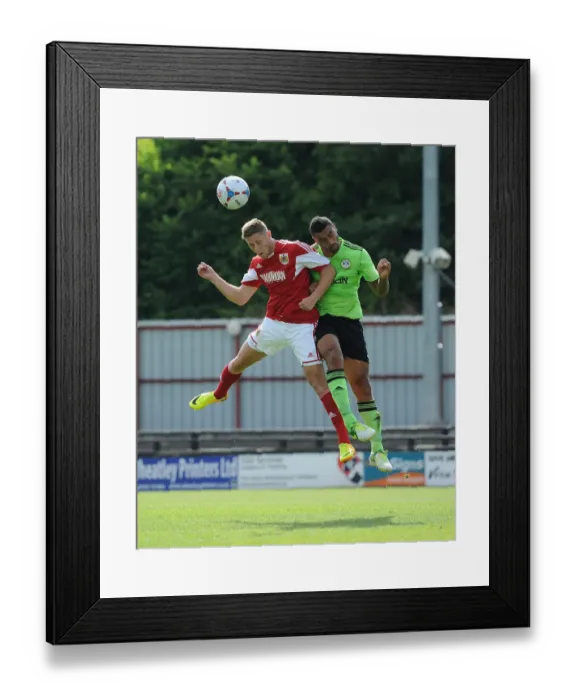 Framed Print : Bristol City's Wes Burns and Forest Green Rovers Jamie Turley Battle for High Ball in Preseason Clash Framed Print : Bristol City's Wes Burns and Forest Green Rovers Jamie Turley Battle for High Ball in Preseason Clash
