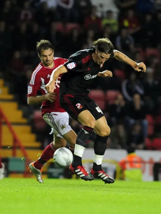 Framed Print : Battling for Supremacy: Brett Pitman vs. Aden Flint in the 2011 League Cup Clash between Bristol City and Swindon Town Framed Print : Battling for Supremacy: Brett Pitman vs. Aden Flint in the 2011 League Cup Clash between Bristol City and Swindon Town