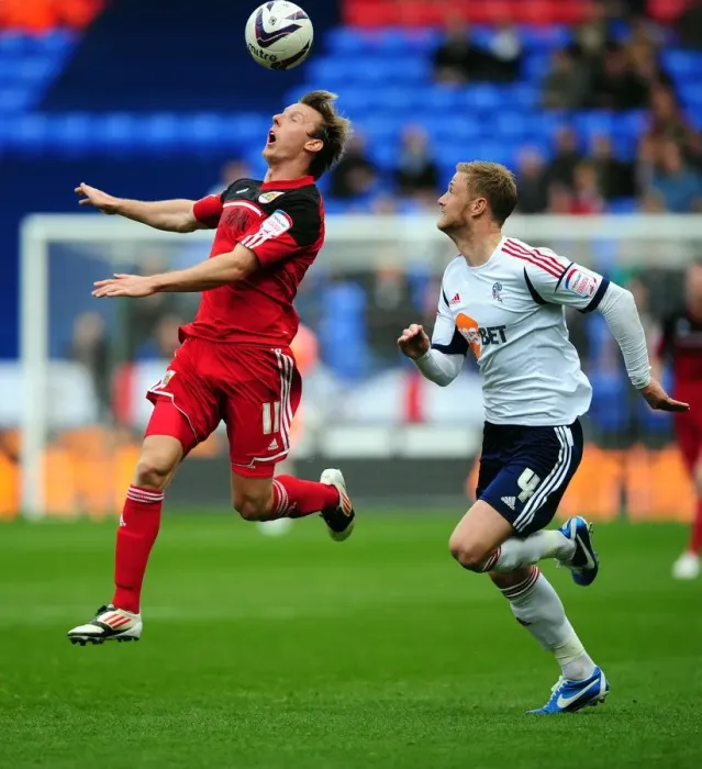 Framed Print : Battling for Supremacy: Woolford vs. Mills in the 2010-11 Championship Clash between Bolton Wanderers and Bristol City