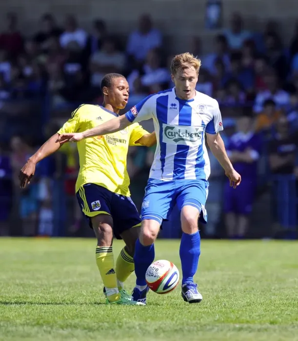 Framed Print : Bobby Reid vs Adi Adams: Intense Battle for the Ball in Clevedon Town vs Bristol City Pre-Season Clash Framed Print : Bobby Reid vs Adi Adams: Intense Battle for the Ball in Clevedon Town vs Bristol City Pre-Season Clash