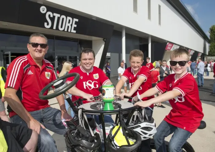 Framed Print : Bristol City Fans Gather Around Children's Hospice South West's Seven-Seater Bike at Ashton Gate Stadium Framed Print : Bristol City Fans Gather Around Children's Hospice South West's Seven-Seater Bike at Ashton Gate Stadium