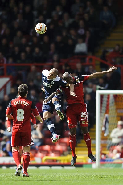 Bristol City vs. Huddersfield: Marvin Elliott and James Vaughan Battle in the Air during the Championship Clash at Ashton Gate