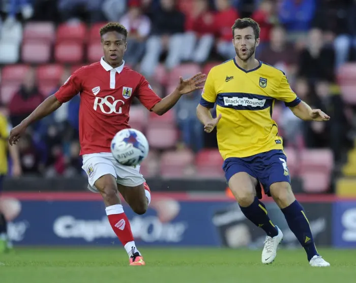 Framed Print : Bristol City vs Oxford United: Bobby Reid Pressures Jonathan Meades in First Round Capital One Cup Clash