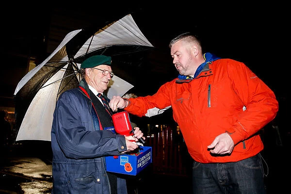 Bristol City's Buster Footman Collects Poppy Donations in the Rain Before Match vs. Wolves