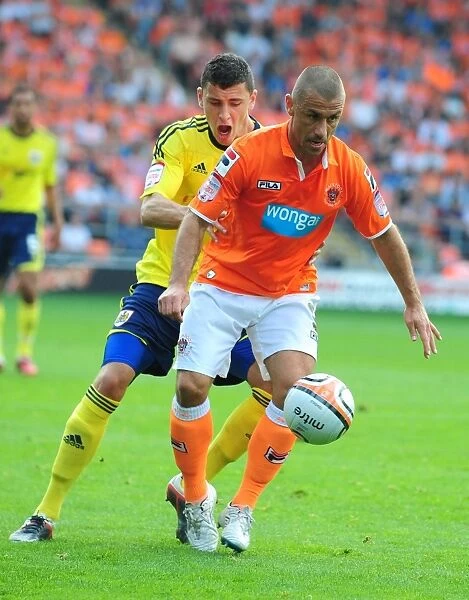 Bristol City's James Wilson vs. Blackpool's Kevin Phillips: Battle for the Ball in 2011 League Cup Match