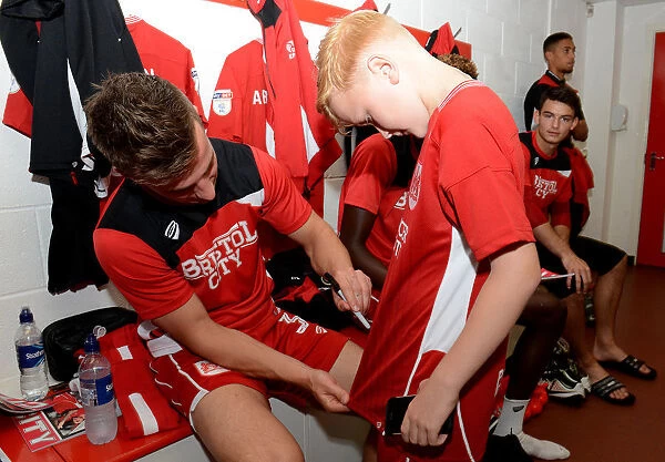 Bristol City's Joe Bryan Signs Autograph for Mascot in Changing Room during Sky Bet Championship Match vs. Wigan Athletic