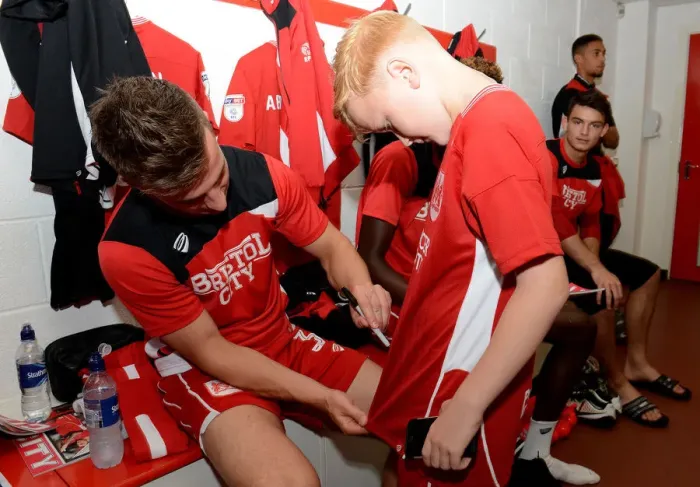 Framed Print : Bristol City's Joe Bryan Signs Autograph for Mascot in Changing Room during Sky Bet Championship Match vs. Wigan Athletic Framed Print : Bristol City's Joe Bryan Signs Autograph for Mascot in Changing Room during Sky Bet Championship Match vs. Wigan Athletic