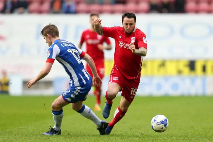 Framed Print : Bristol City's Lee Tomlin Faces Off Against Wigan Athletic's Callum Connolly in Championship Clash