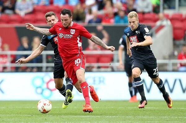 Bristol City's Lee Tomlin Outmaneuvers Derby County's Bryson and Vydra