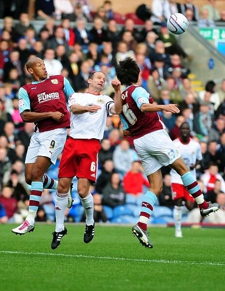 Bristol City's Louis Carey Battles for Aerial Ball Against Burnley's Iwelumo and Cork in Championship Match, 2010