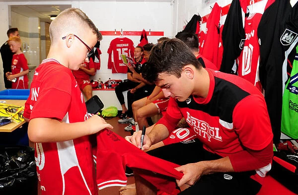 Bristol City's Max O'Leary Signs Autograph for Mascot in Changing Room during Bristol City v Wigan Athletic Match