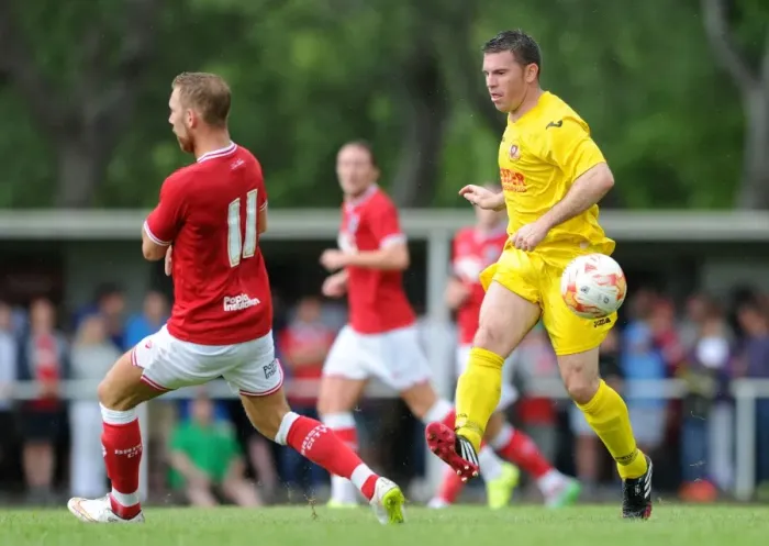 Framed Print : Bristol City's Scott Wagstaff Closes In on Brislington's James Peart During Pre-Season Friendly Framed Print : Bristol City's Scott Wagstaff Closes In on Brislington's James Peart During Pre-Season Friendly