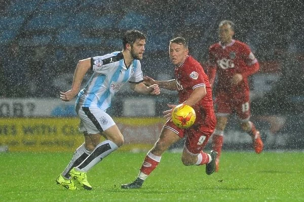 Bristol City's Simon Cox Closes In on Huddersfield Ball in Championship Clash