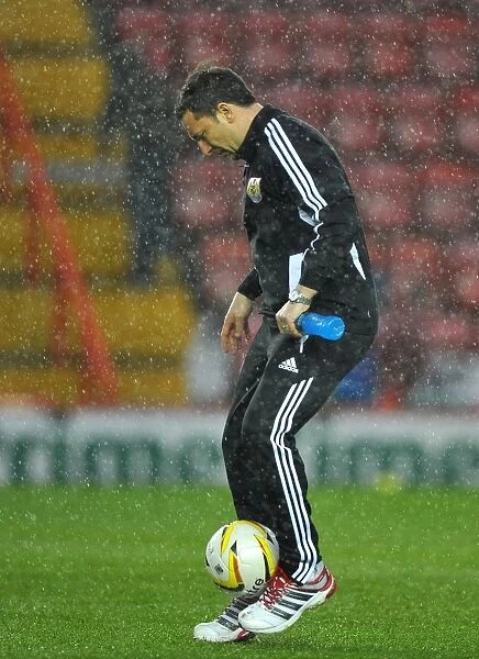 Derek McInnes Examines the Floodlit Pitch as Championship Match between Bristol City and Watford is Aborted (December 26, 2012)