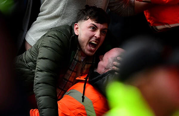 Exuberant Cardiff City Fan Celebrates with Steward Amidst the Thrills of Bristol City vs. Cardiff City Championship Clash