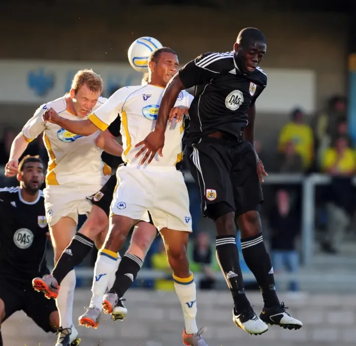 Framed Print : John Akinde Battles for Aerial Supremacy: Torquay vs. Bristol City