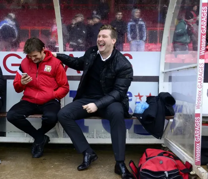 Framed Print : Milton Keynes Dons Manager Karl Robinson Shares a Light-Hearted Moment with His Bench Before the Bristol City Match