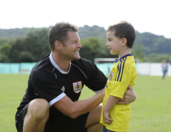 Steve Cotterill Engages with Young Fan at Portishead Town vs. Bristol City Match