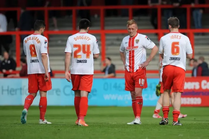 Framed Print : Stevenage players cut dejected figures after the game as they lose 1 - 3 to Bristol City resulting in them being