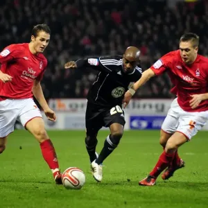 Battling for Supremacy: Jamal Campbell-Ryce Fights Off Luke Chambers and Chris Cohen of Nottingham Forest in Npower Championship Clash