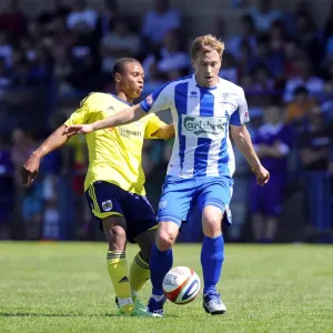 Bobby Reid vs Adi Adams: Intense Battle for the Ball in Clevedon Town vs Bristol City Pre-Season Clash Bobby Reid vs Adi Adams: Intense Battle for the Ball in Clevedon Town vs Bristol City Pre-Season Clash