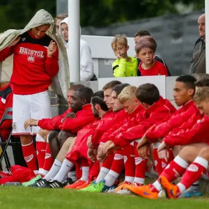 Joe Bryan shields himself from the rain during a pre-season match