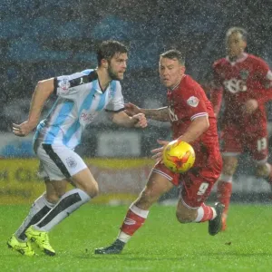 Bristol City's Simon Cox Closes In on Huddersfield Ball in Championship Clash Bristol City's Simon Cox Closes In on Huddersfield Ball in Championship Clash