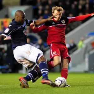 Championship Showdown: Intense Moment as Millwall's Danny Shittu Challenges Bristol City's Martyn Woolford in the Penalty Box