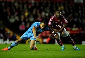 Images Dated 17th April 2012: Battling for the Ball: Amougou vs. Carew at Ashton Gate Stadium, 2012