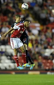 Images Dated 27th August 2013: Bobby Reid vs. Stuart O'Keefe: Intense Battle for the High Ball in Bristol City vs