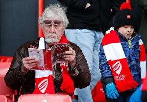 Fans Collection: Bristol City Fan Absorbed in Match Program before FA Cup Clash vs. West Ham United