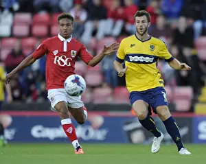 Capital One Prints: Bristol City vs Oxford United: Bobby Reid Pressures Jonathan Meades in First Round Capital One Cup Clash