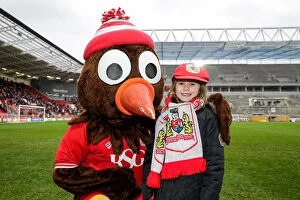 Images Dated 13th February 2016: Bristol City's Scrumpy Mascot Presents Cap to Young Fan at Ashton Gate Stadium