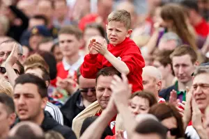 Champions Prints: A spectacle wearing dog is held up by its owner as thousands of fans pack Lloyds Amphitheatre during the Bristol City